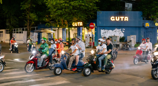 20-20 members explore Saigon on a nighttime scooter tour.